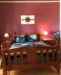 a bedroom with a wooden bed and two lamps at Armadale House - Kingscote in Kingscote