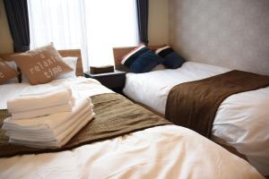 dos camas sentadas una al lado de la otra en una habitación en Ambiera Doza en Nagasaki