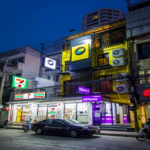 a car parked in front of a building with signs at Matchbox Bangkok Hostel in Bangkok