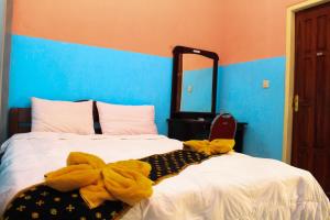 um quarto com uma cama com uma toalha amarela em Hotel Edelweis 2 Bajawa em Bajawa