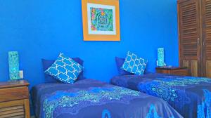 two beds in a room with blue walls at Villa Star of the Sea in Barra de Navidad