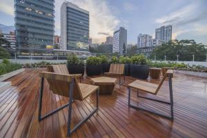 una terraza con sillas y mesas en la parte superior de un edificio en City Express Plus by Marriott Medellín Colombia, en Medellín