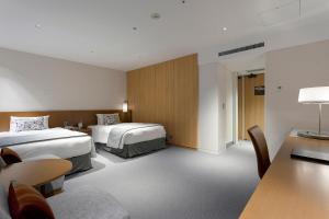 a hotel room with two beds and a table at Keio Plaza Hotel Tokyo in Tokyo