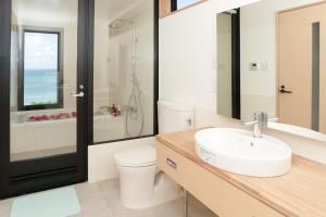 een badkamer met een wastafel, een toilet en een douche bij Villa SACHIIBARU in Nanjo