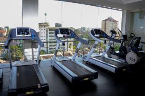 a gym with three tread machines in front of a window at Royal Canaan Nairobi Hotel in Nairobi