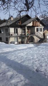 een groot huis met een balkon in de sneeuw bij La Grande Lauze in Champcella