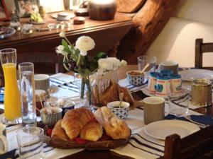 einen Tisch mit einem Teller Croissants und Brot darauf in der Unterkunft Les Toits de Paris in Paris