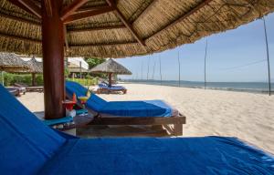 a beach with two beds and umbrellas on the beach at Blue Ocean Resort in Mui Ne