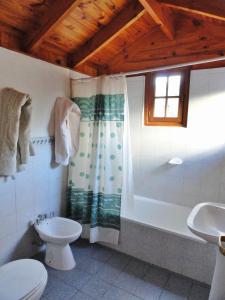 uma casa de banho com uma banheira, um WC e um lavatório. em Las Vertientes Lodge em San Martín de los Andes