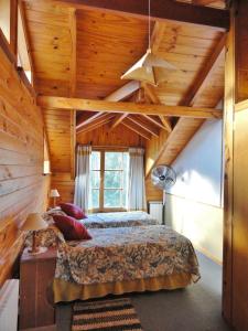 een slaapkamer met een bed en een houten plafond bij Las Vertientes Lodge in San Martín de los Andes