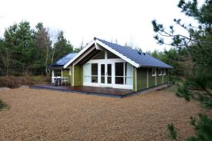 una piccola cabina verde con terrazza in giardino di Hjortestien 7 a Henne Strand
