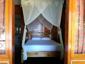 1 dormitorio con 1 cama con dosel en Raja Laut Dive Resort Bunaken, en Bunaken