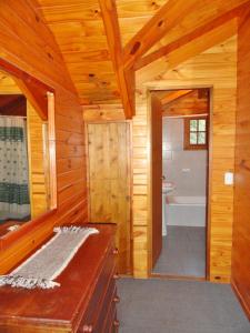 baño de madera con bañera y lavamanos en Las Vertientes Lodge en San Martín de los Andes