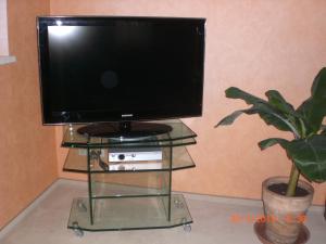 einen Fernseher auf einem Glasstand mit einer Anlage in der Unterkunft Ferienwohnung Böhm in Kranichfeld