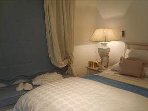 a bedroom with a white bed with a lamp and a bed sidx sidx at Emerald Guest House Springs in Springs