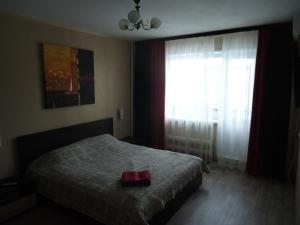 - une chambre avec un lit et une grande fenêtre dans l'établissement Apartments on Gagarina 9, à Volgodonsk