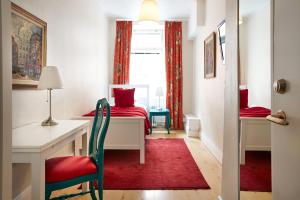 a small bedroom with a desk and a red rug at Hotel Hornsgatan in Stockholm