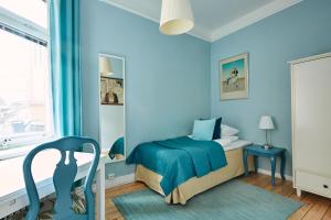 a blue bedroom with a bed and a chair at Hotel Hornsgatan in Stockholm