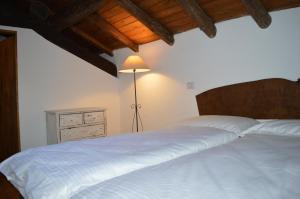 a bedroom with a white bed and a lamp at Il pensiero in Lenno