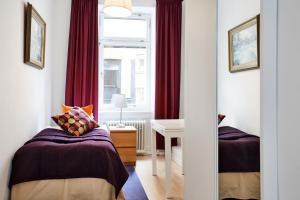 a bedroom with two beds and a desk and a window at Hotel Hornsgatan in Stockholm