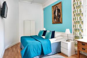 a blue and white bedroom with a bed with blue sheets at Hotel Hornsgatan in Stockholm