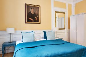 a bedroom with a blue bed with a painting on the wall at Hotel Hornsgatan in Stockholm