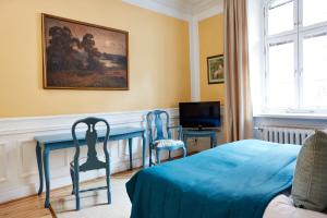 a bedroom with a blue table and two chairs at Hotel Hornsgatan in Stockholm