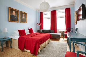 a bedroom with a bed with a red blanket at Hotel Hornsgatan in Stockholm