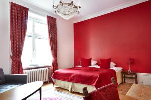 a red bedroom with a bed and a chandelier at Hotel Hornsgatan in Stockholm