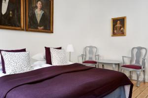 a bedroom with a purple bed and two chairs at Hotel Hornsgatan in Stockholm