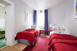 a bedroom with two beds and a red blanket at Hotel Hornsgatan in Stockholm