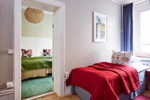 a bedroom with a red blanket on a bed at Hotel Hornsgatan in Stockholm
