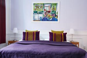 a bedroom with a purple bed with two lamps at Hotel Hornsgatan in Stockholm