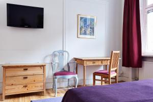 a bedroom with a desk and a table and chairs at Hotel Hornsgatan in Stockholm