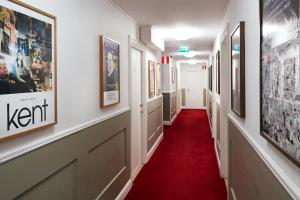 a hallway with a red carpet and pictures on the walls at Hotel Hornsgatan in Stockholm