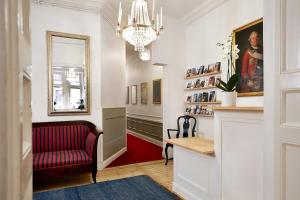 a hallway with a red chair and a mirror at Hotel Hornsgatan in Stockholm