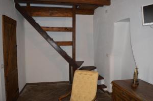 レンノにあるIl pensieroの椅子と木製の階段が備わる部屋