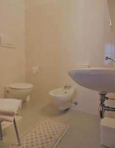 a white bathroom with a sink and a toilet at Hotel Zeni in Brentonico