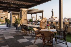 a patio with tables and chairs on a roof at Emperador in Madrid