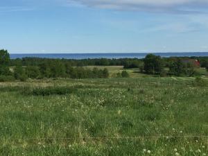 un campo de césped verde con una valla y árboles en Rolösa, en Hjo