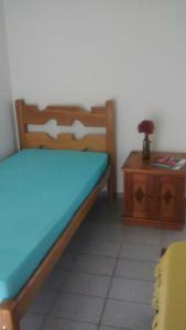 a bedroom with a bed and a wooden table at Casa Praia do Forte in Cabo Frio