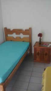 1 dormitorio con cama y mesa de madera en Casa Praia do Forte, en Cabo Frío