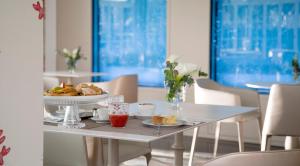 una mesa blanca con un plato de comida. en Hotel Feldberg, en Riccione