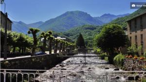 una calle con árboles y montañas en el fondo en Appartement à la montagne en Aulus-les-Bains