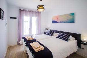 a bedroom with two beds with towels on them at Flower Beach Suite 6 in Playa Honda +46 photos