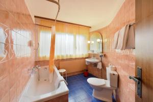 a bathroom with a tub and a toilet and a sink at Schlosshotel - Self Check-In Hotel in Brig +39 photos