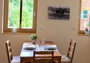 a dining room table with chairs and a wooden table at Ferienwohnung im Kuhstall in Neustadt am Rübenberge