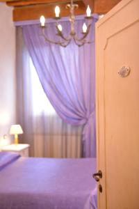 a bedroom with a purple bed with a window at B&B La Casa dei Tintori in Florence