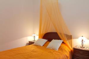 um quarto com uma cama laranja e duas mesas de cabeceira em Casa Alto Santo António em Ponta do Sol