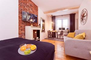 a room with a bed with a plate of fruit on it at Pomorskie Apartamenty Biała Mewa in Sopot